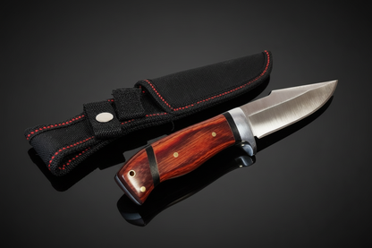 Jagdmesser mit festem Blatt und echtem braunem Holzgriff neben schwarzer Cordura-Scheide mit roter Naht – dunkler Hintergrund mit Spiegeleffekt