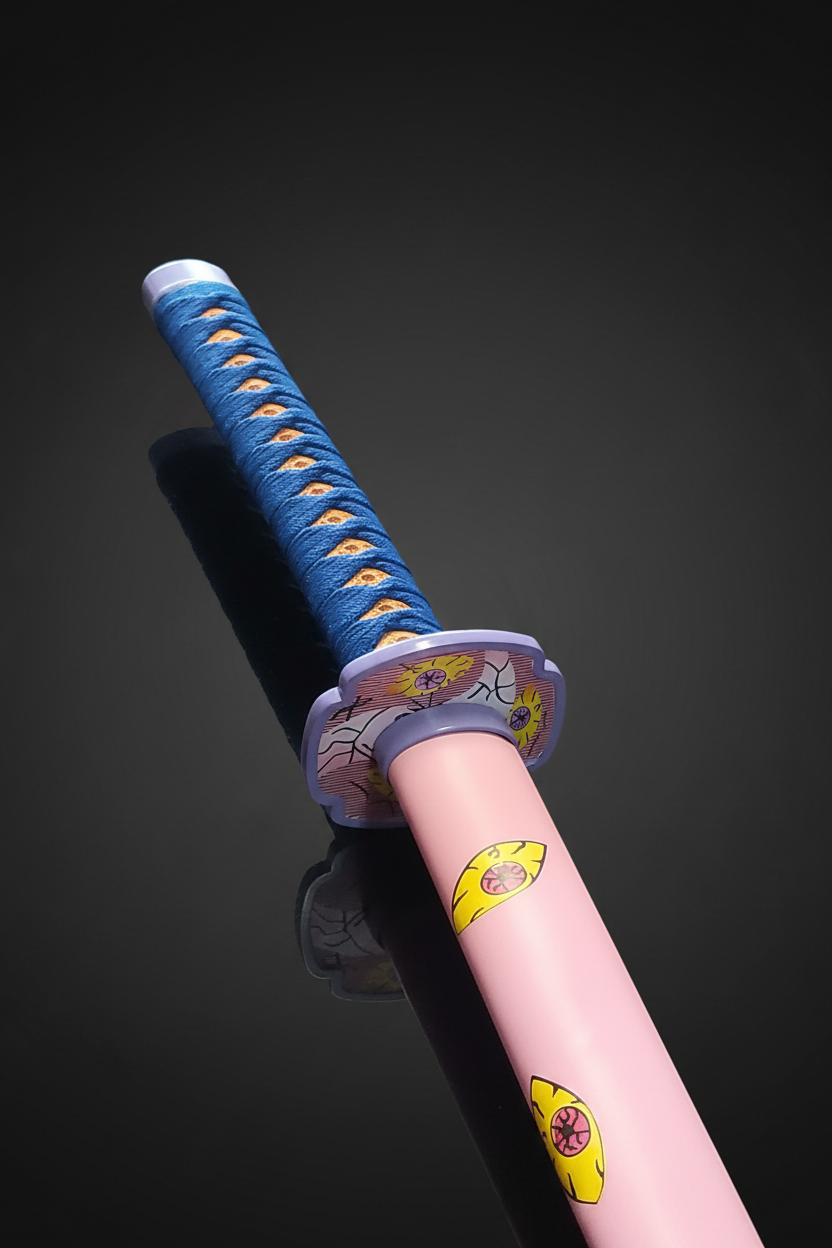 Dettaglio ravvicinato dell’impugnatura (tsuka) della katana Kokushibou Demon Slayer: avvolgimento blu con motivi a occhio giallo, tsuba circolare grigia con decorazioni floreali e inizio del fodero rosa con occhi gialli – replica fedele Tsugikuni Michikatsu per cosplay e collezione
