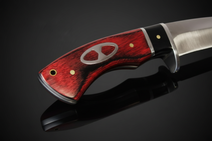 Détail du manche en vrai bois rouge foncé du couteau à lame fixe avec garde en métal – fond sombre avec effet miroir