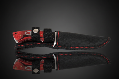 Cuchillo de hoja fija con mango de madera roja en funda de Cordura negra con costura roja y clip de cinturón – fondo oscuro con efecto espejo