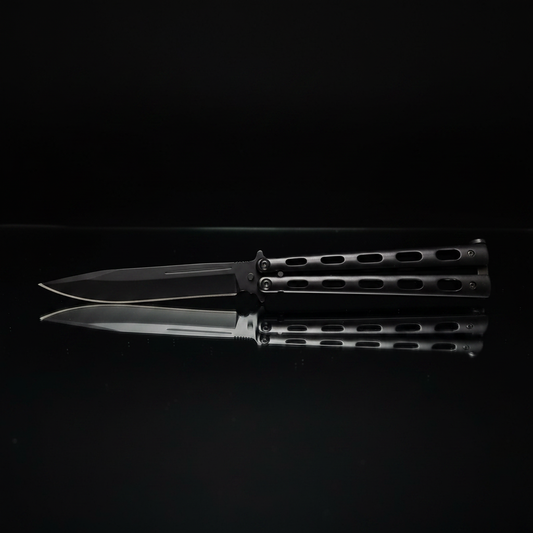 Coltello butterfly balisong acciaio AISI 420 nero su piano specchio sfondo scuro