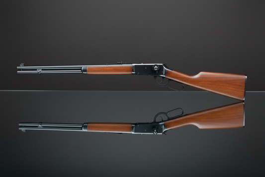 Double Bell Winchester M1894 su sfondo grigio scuro con piano a specchio