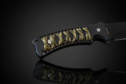 Detalle del mango del cuchillo Cougar Collection en ABS negro con cordura de camuflaje entrelazada y remaches metálicos – fondo oscuro con efecto espejo