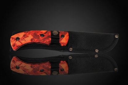 Fixed blade Skinner hunting knife with orange camouflage ABS handle fully inserted in black Cordura sheath with belt attachment – dark background with mirror effect